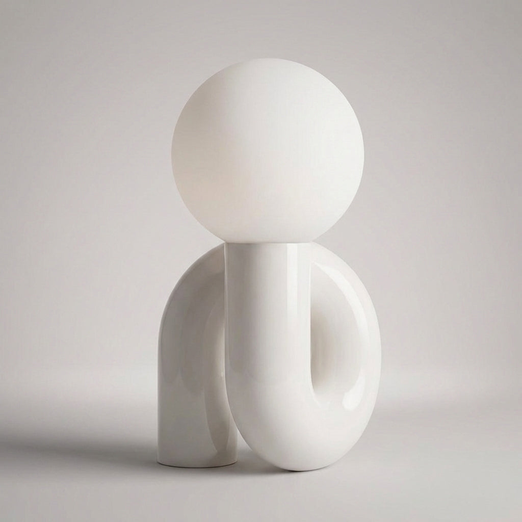 Skulpturel bordlampe med resinbase og kugle i matteret glas