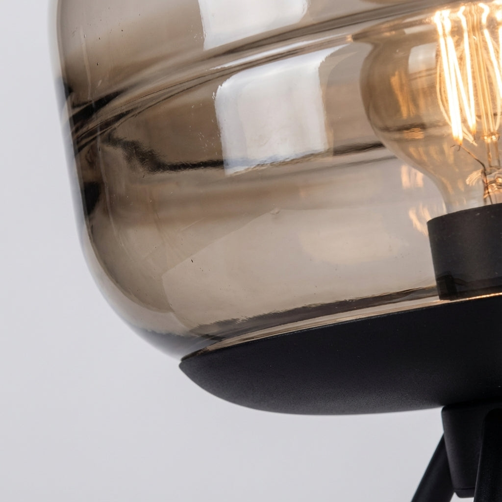 Skulpturale Tischlampe mit vierbeinigem Metallsockel und Glasschirm