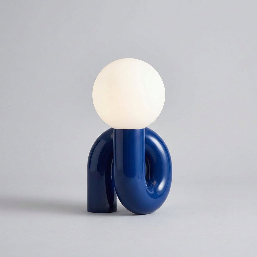 Skulpturel bordlampe med resinbase og kugle i matteret glas