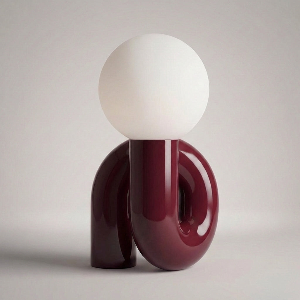 Skulpturel bordlampe med resinbase og kugle i matteret glas