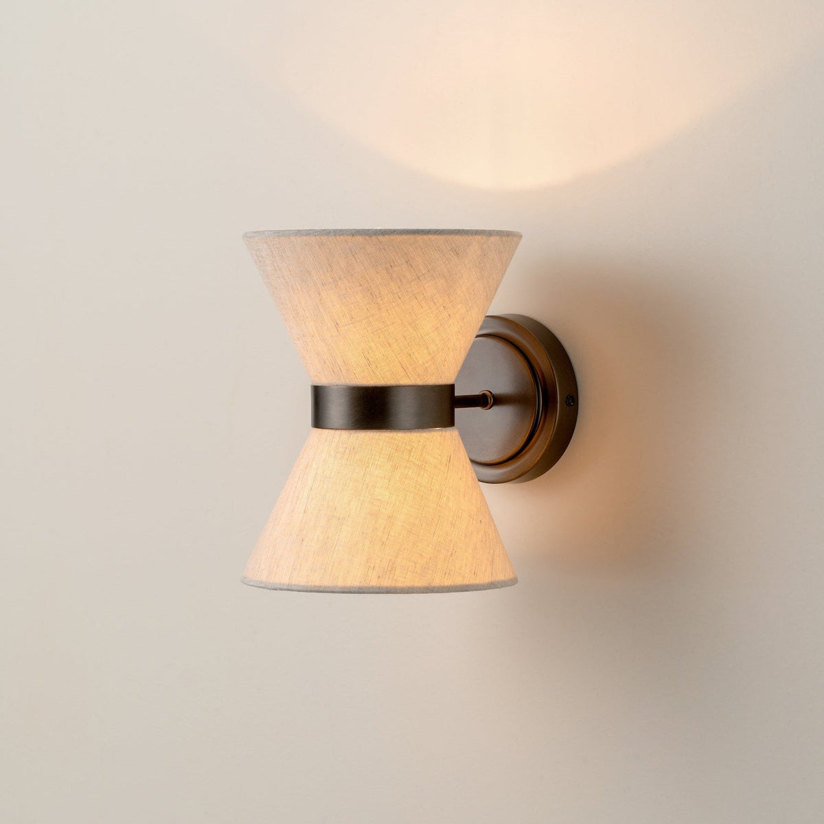 Klassisch-moderne Wandleuchte mit gealtertem Bronze-Finish und Leinenschirm